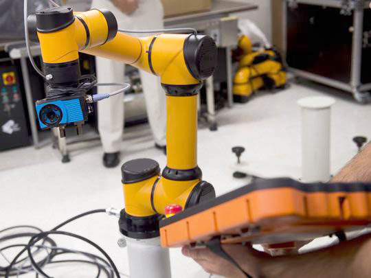 Engenheiros testando câmera com um Aubo e buscando novos avanços na robótica industrial.