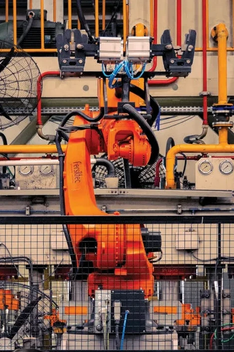 Robô industrial em célula de estamparia automatizada